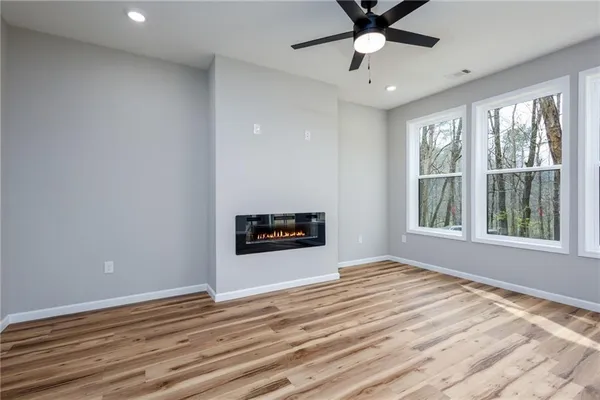 a view of an empty room with a window and a ceiling fan