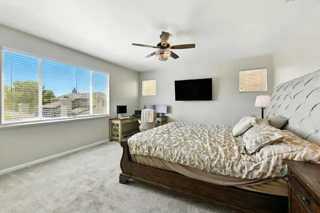 a bedroom with a bed and a large window