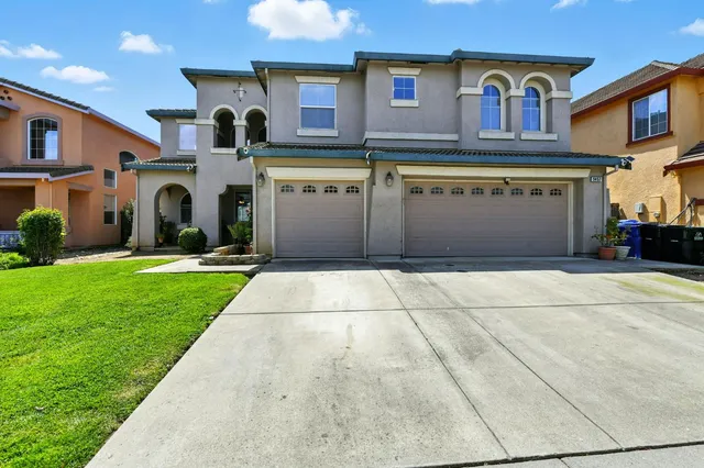 a front view of a house with a garden and yard