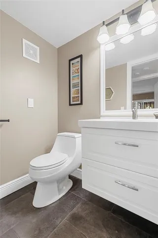 a bathroom with a toilet sink and a mirror