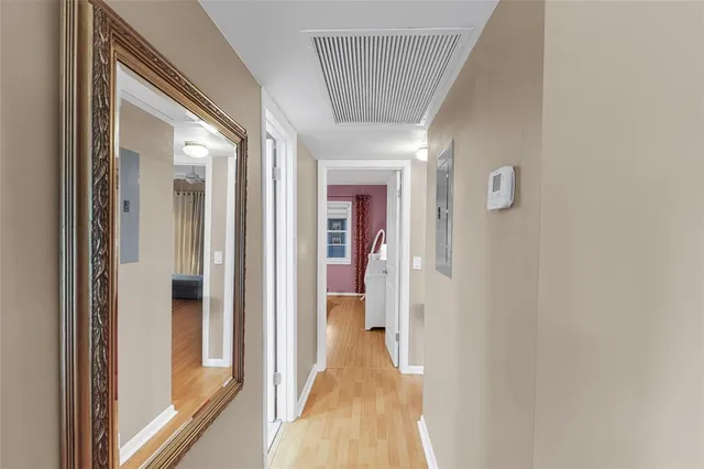 a view of a hallway with wooden floor and staircase