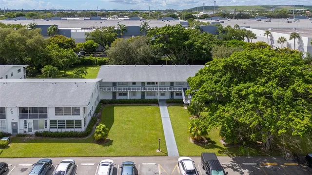 an aerial view of a house with a garden and lake view