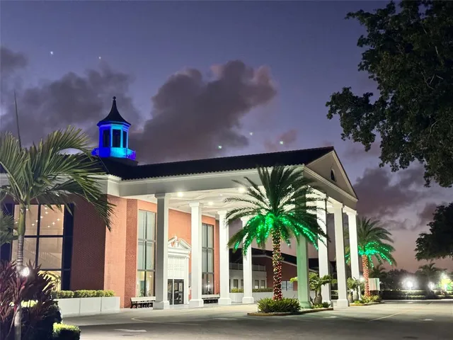 a front view of a house with a yard glass windows and potted plants