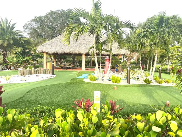 a view of a fountain in front of a house with a big yard