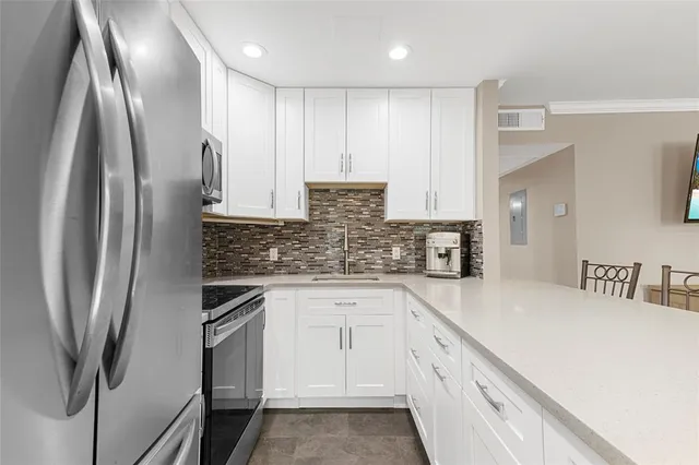 a kitchen with stainless steel appliances a refrigerator sink and white cabinets