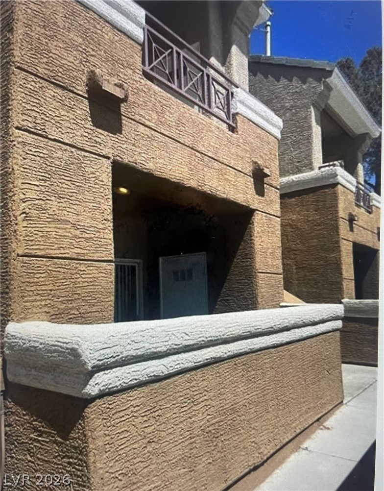 8070 West Russell Road, Unit 1092 Las Vegas, NV 89113 - Photo 2 of 14 Private covered patios showcase textured stucco finishes under clear blue skies.