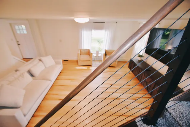 a living room with wooden floor and a flat screen tv