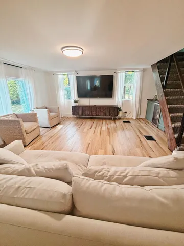 a spacious bedroom with a bed and wooden floor