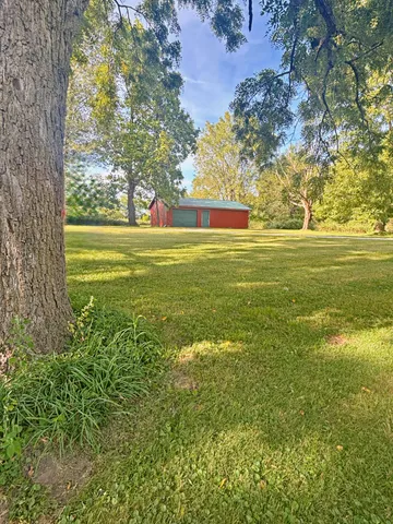 a front view of house with yard and trees all around