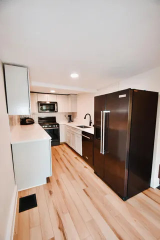 a kitchen with stainless steel appliances a refrigerator and a stove top oven