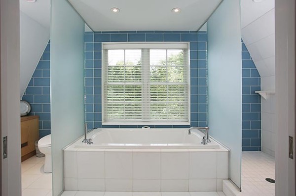76 Denny Road Brookline, MA 02467 - Photo 7 of 11 a white bath tub sitting in a bathroom next to a window