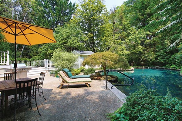 76 Denny Road Brookline, MA 02467 - Photo 10 of 11 an outdoor sitting area with couch and umbrella