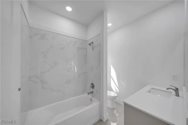 a bathroom with a tub sink vanity and a mirror