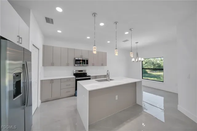 a kitchen with stainless steel appliances granite countertop a sink stove and refrigerator