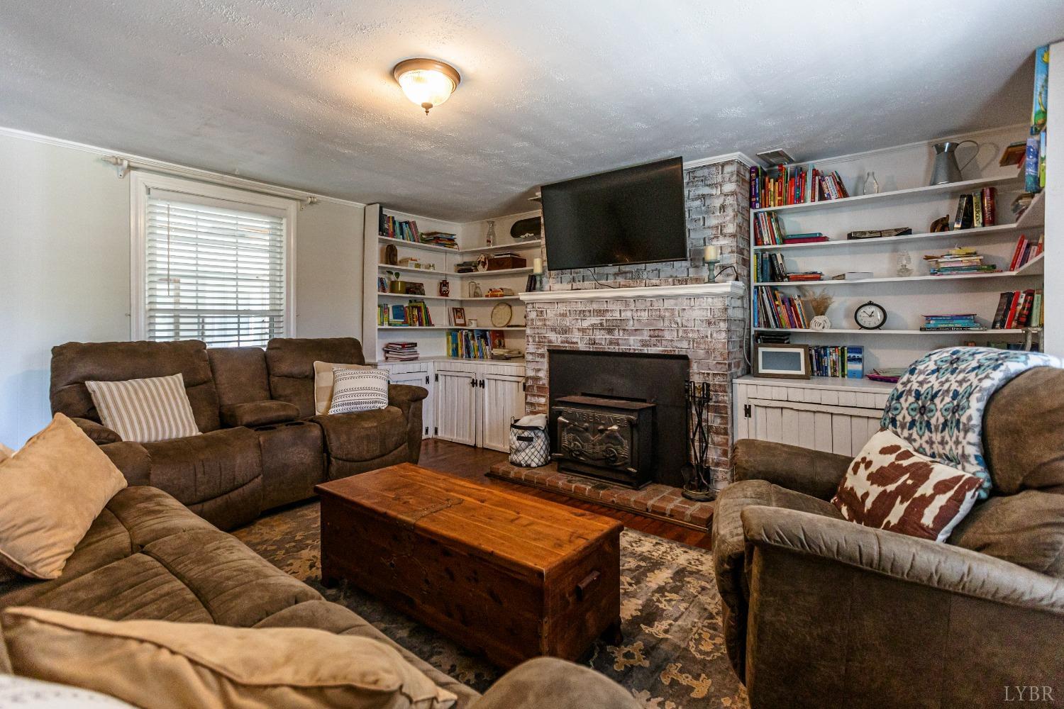 1564 Swan Road Pamplin, VA 23958 - Photo 13 of 60 a living room with furniture a flat screen tv and a fireplace