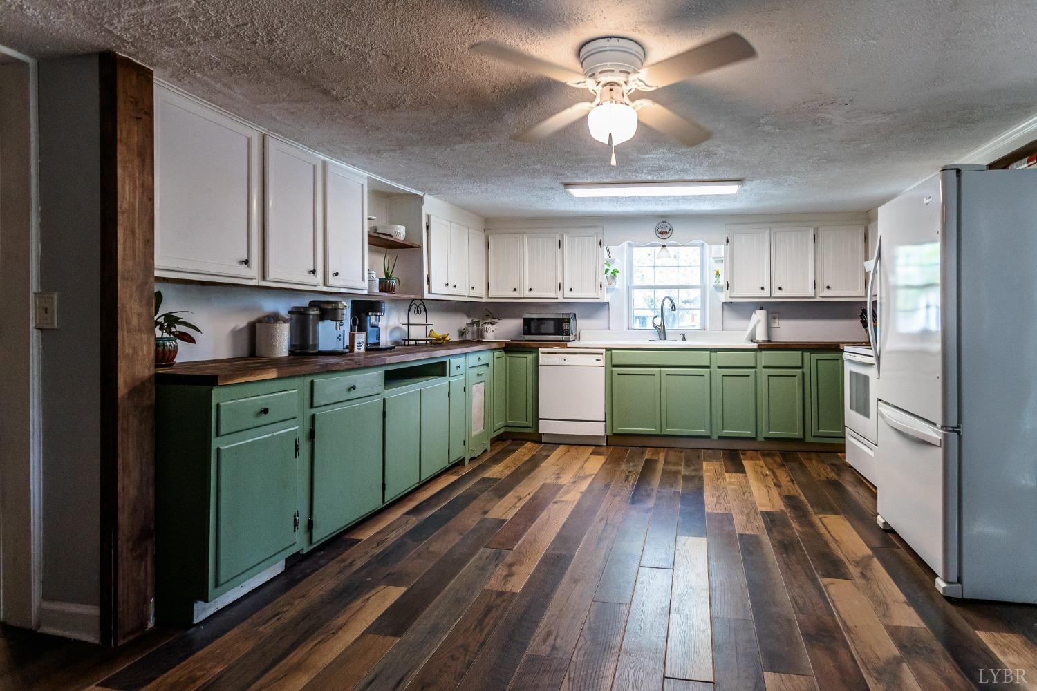 1564 Swan Road Pamplin, VA 23958 - Photo 15 of 60 a kitchen with cabinets a sink dishwasher and a stove with wooden floor