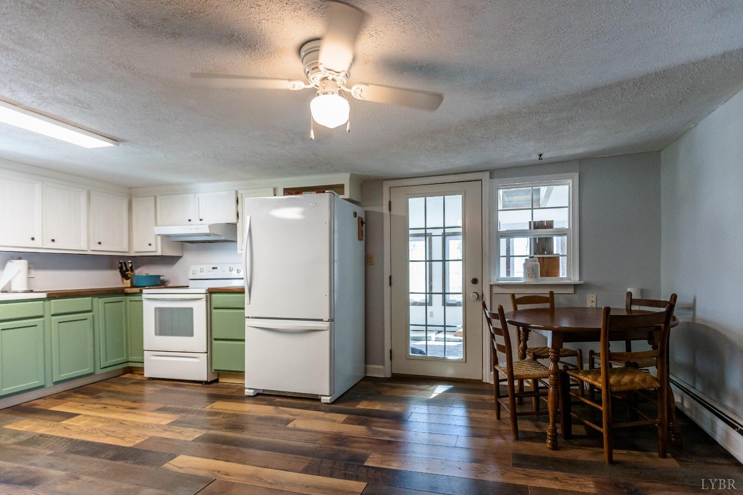 1564 Swan Road Pamplin, VA 23958 - Photo 16 of 60 a kitchen with a refrigerator a stove dining table and chairs