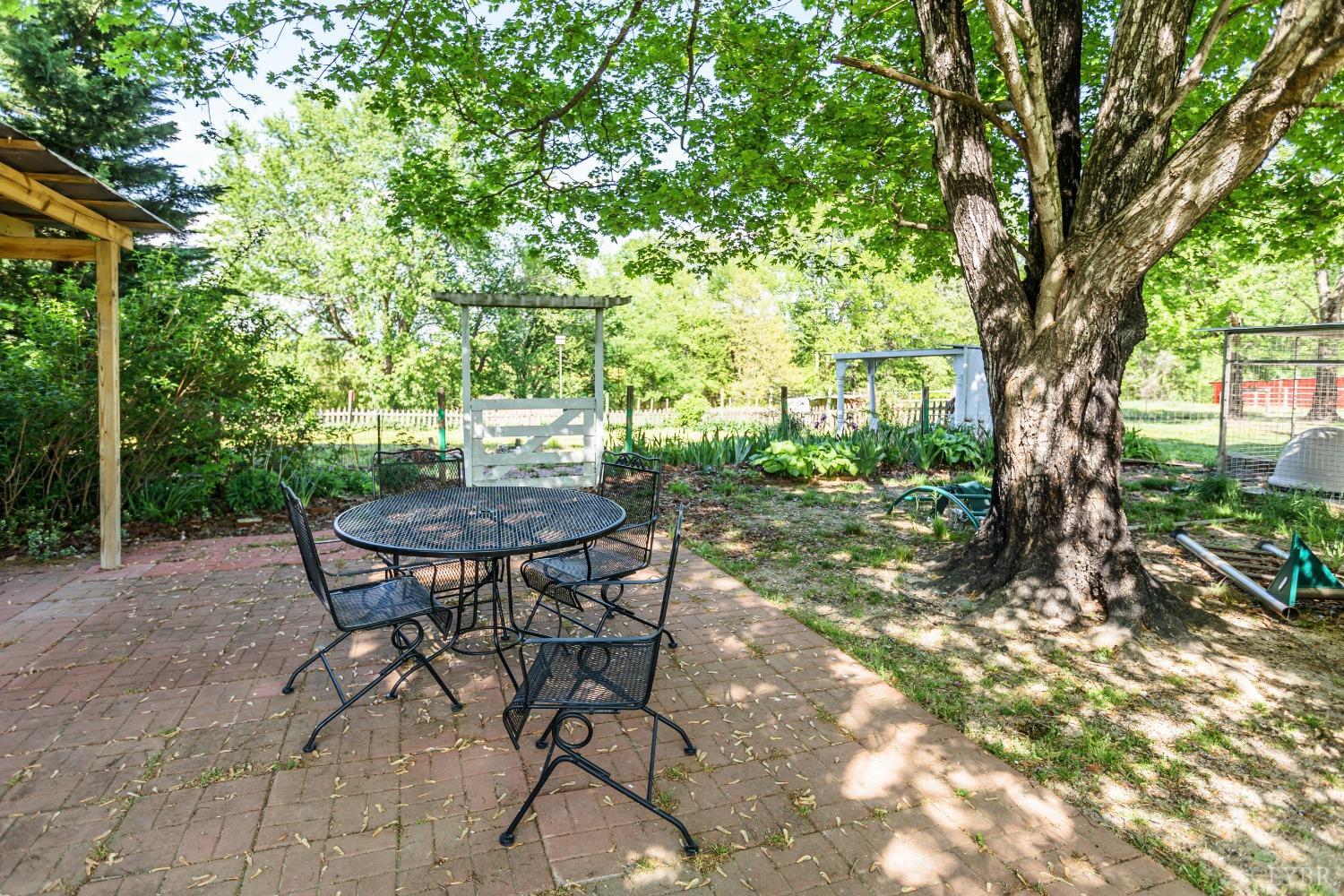 1564 Swan Road Pamplin, VA 23958 - Photo 46 of 60 a view of patio with table and chairs and couches with large trees