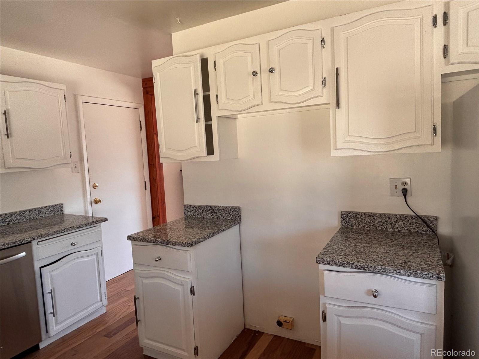 2771 South Perry Street Denver, CO 80236 - Photo 12 of 40 a bathroom with granite countertop white cabinets and a sink