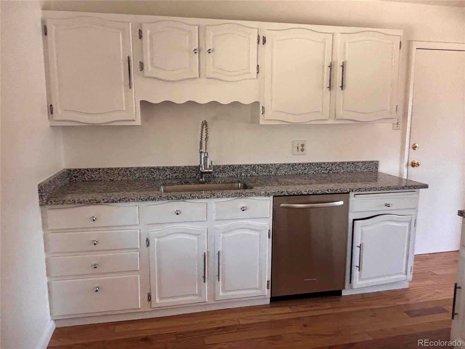 2771 South Perry Street Denver, CO 80236 - Photo 13 of 40 a kitchen with white cabinets and sink