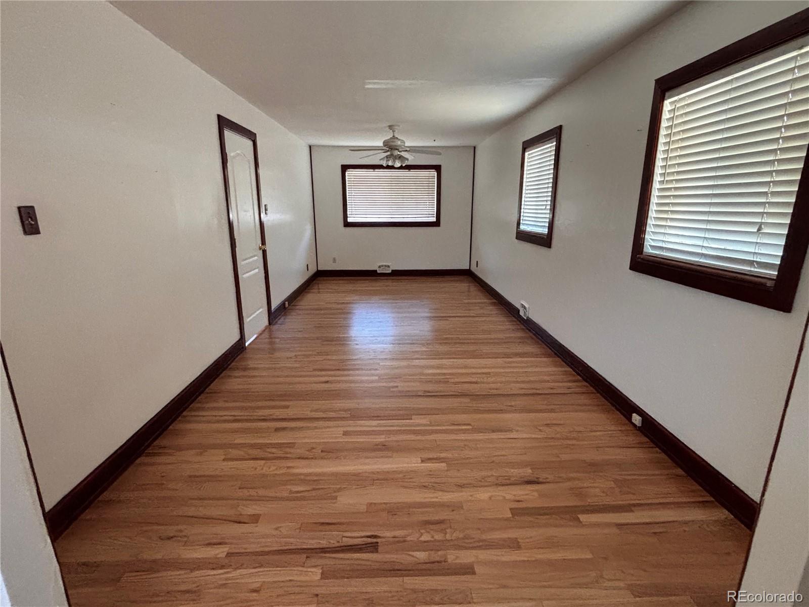 2771 South Perry Street Denver, CO 80236 - Photo 15 of 40 a view of an empty room with wooden floor and a window