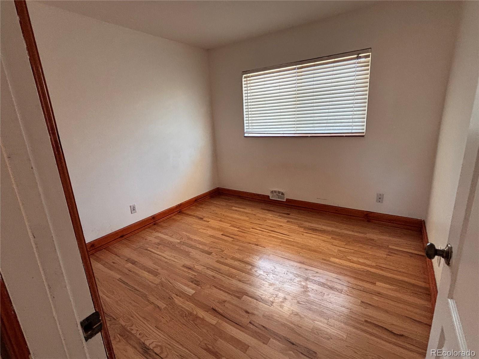 2771 South Perry Street Denver, CO 80236 - Photo 17 of 40 an empty room with wooden floor and windows