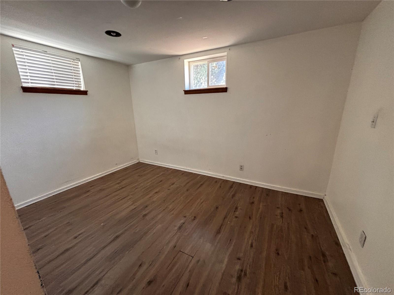 2771 South Perry Street Denver, CO 80236 - Photo 24 of 40 an empty room with wooden floor and windows