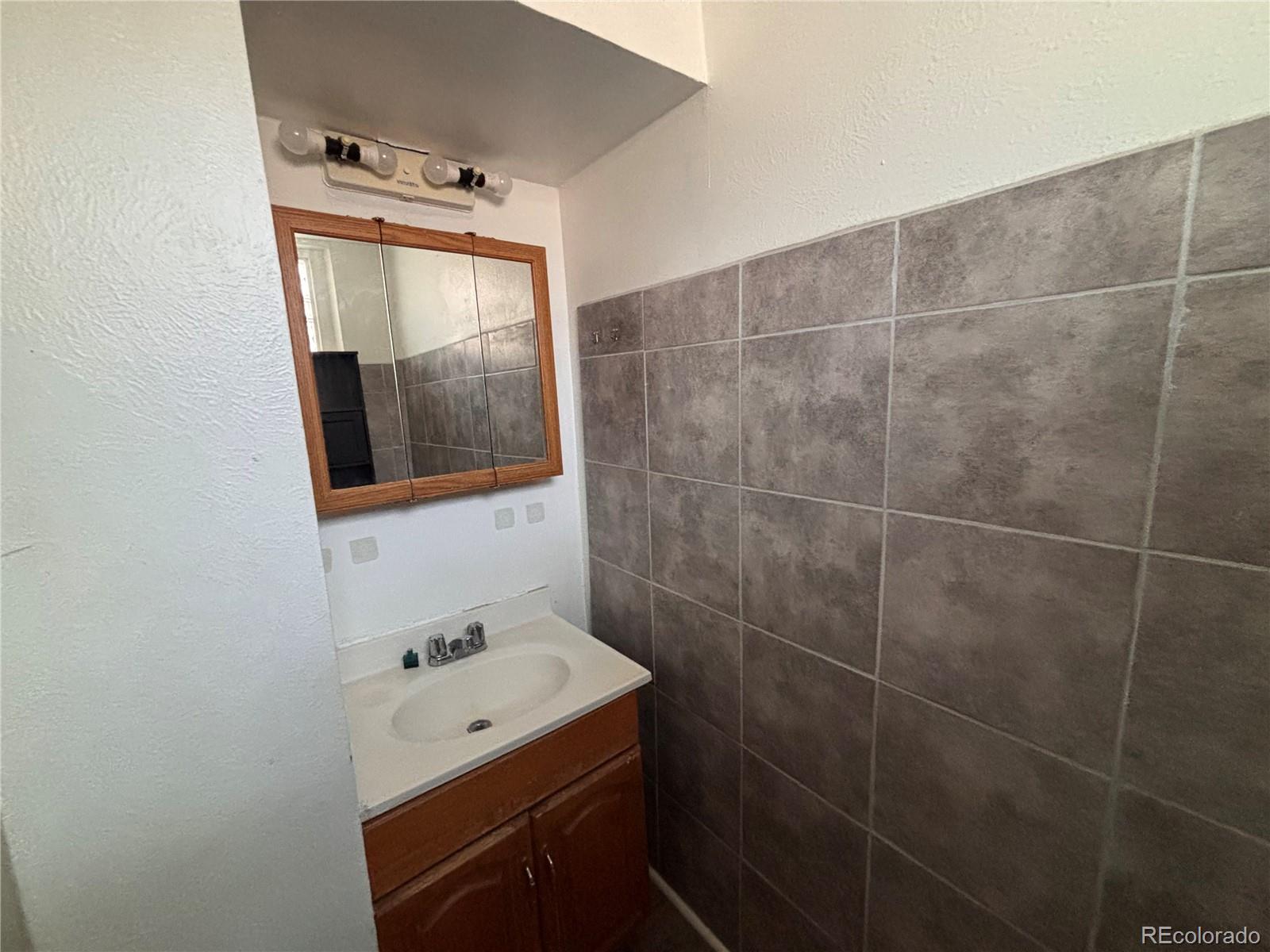 2771 South Perry Street Denver, CO 80236 - Photo 27 of 40 a bathroom with a sink mirror and toilet