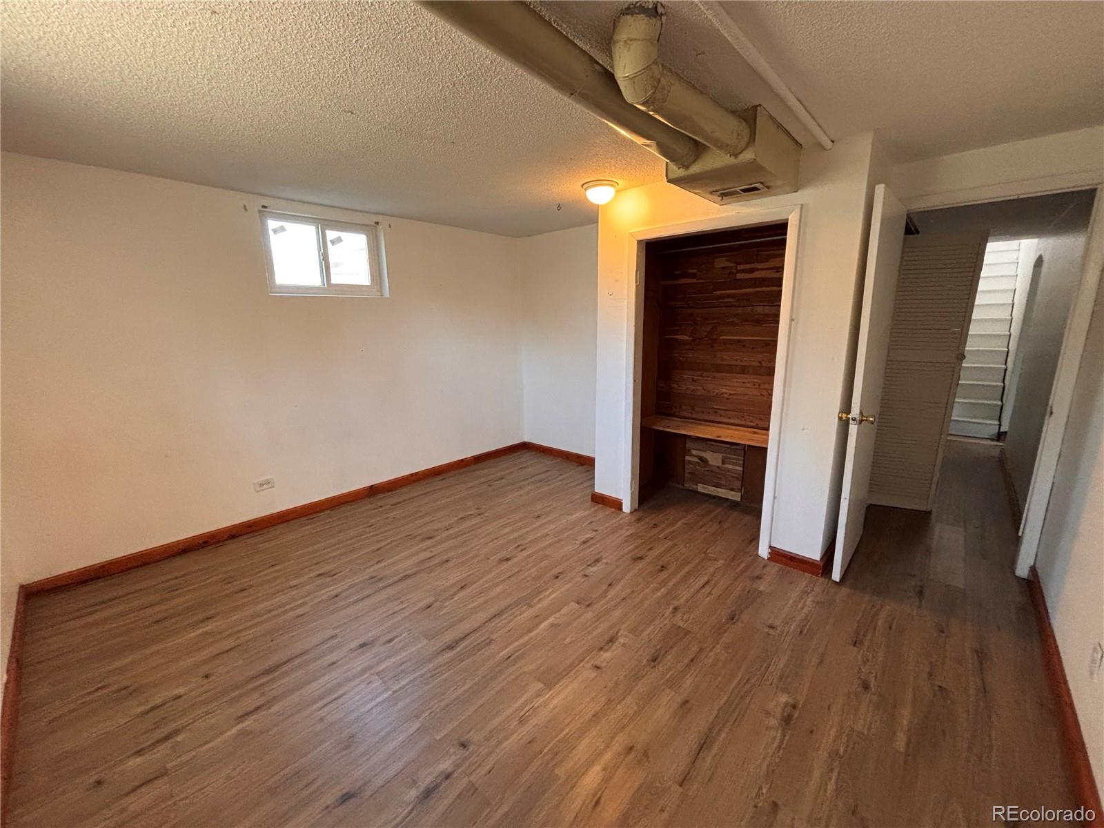 2771 South Perry Street Denver, CO 80236 - Photo 29 of 40 an empty room with wooden floor and entrance