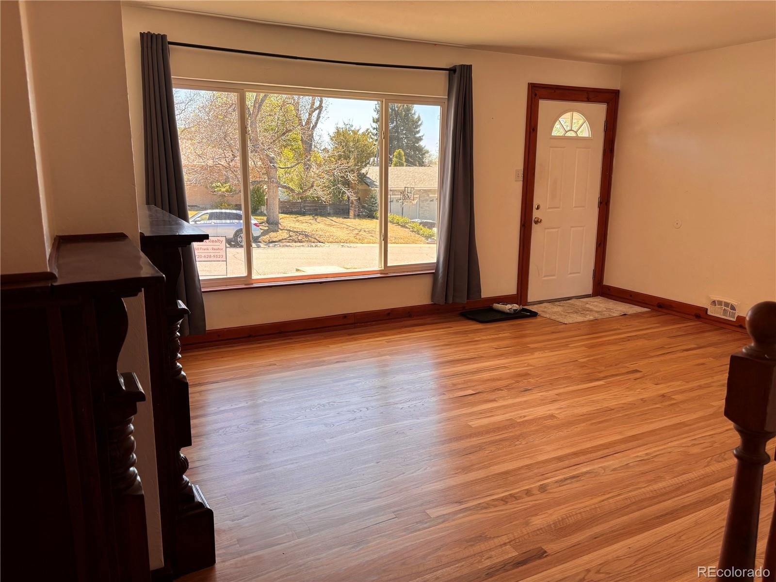 2771 South Perry Street Denver, CO 80236 - Photo 8 of 40 a view of an empty room with wooden floor and a window