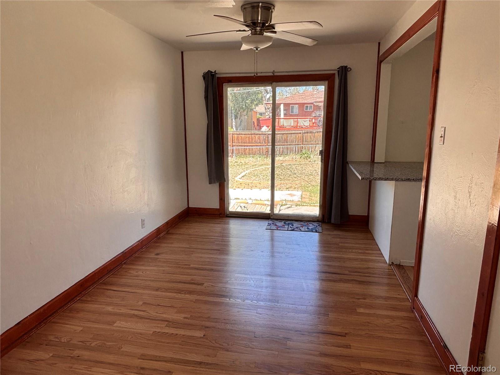 2771 South Perry Street Denver, CO 80236 - Photo 10 of 40 wooden floor in an empty room with a window