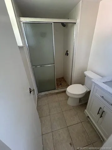 a bathroom with a granite countertop toilet and a shower