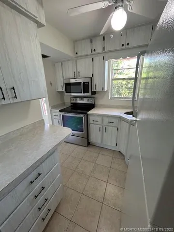 a kitchen with stainless steel appliances a sink a stove a microwave and cabinets