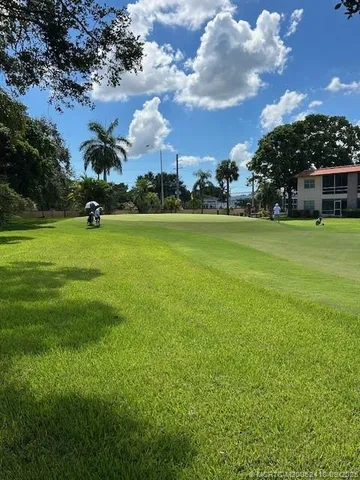 a view of a house with a yard and a fountain