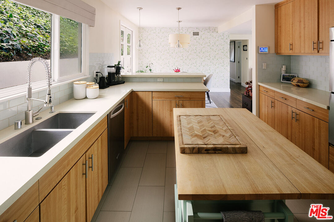 3346 Coy Drive Sherman Oaks, CA 91423 - Photo 13 of 41 a kitchen with kitchen island granite countertop a sink stove and cabinets