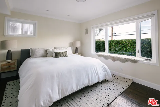 a bedroom with a bed and a large window