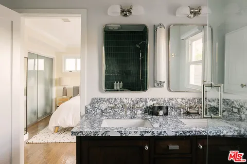 a bathroom with kitchen island granite countertop a sink and a wooden cabinets