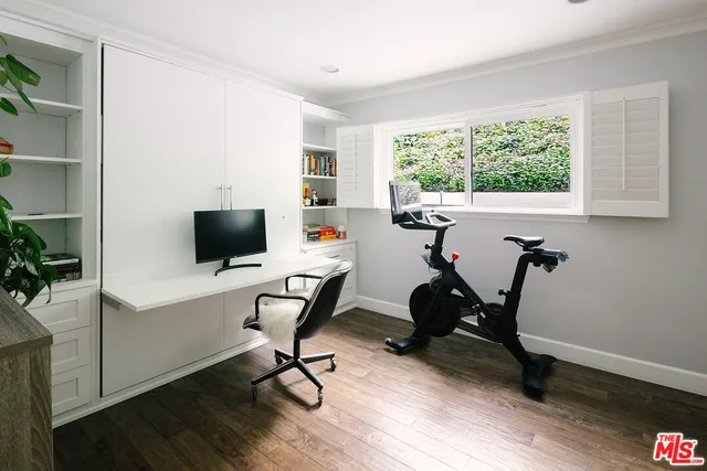 a view of a workspace with furniture and a window