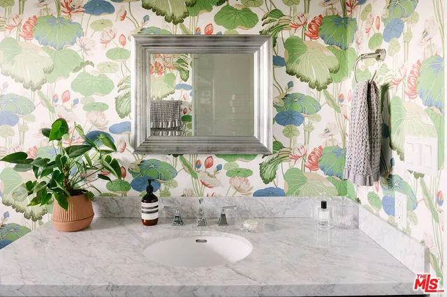 a bathroom with a sink a mirror and a shower