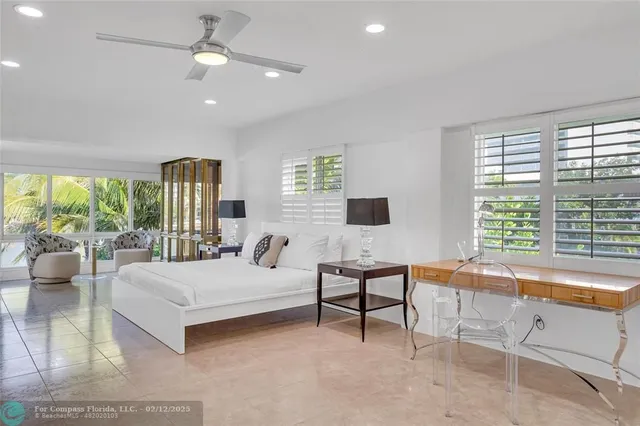 a bedroom with a bed and a large window