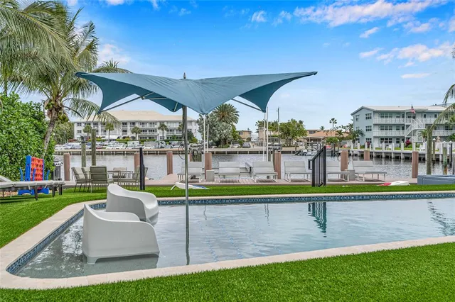 a view of a house with a swimming pool and sitting area