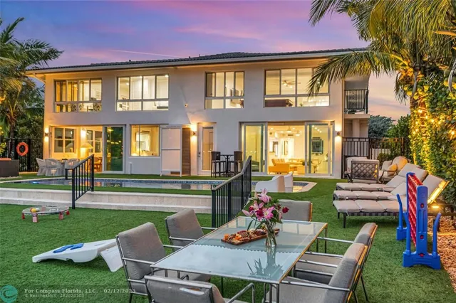 a view of a house with a swimming pool and sitting area