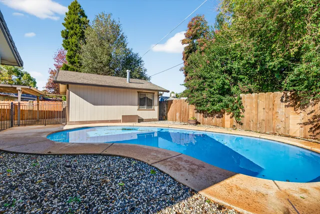 a view of a house with pool and sitting area