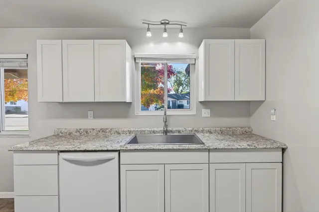 a kitchen with stainless steel appliances granite countertop a sink stove and cabinets