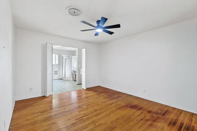 a view of empty room with wooden floor