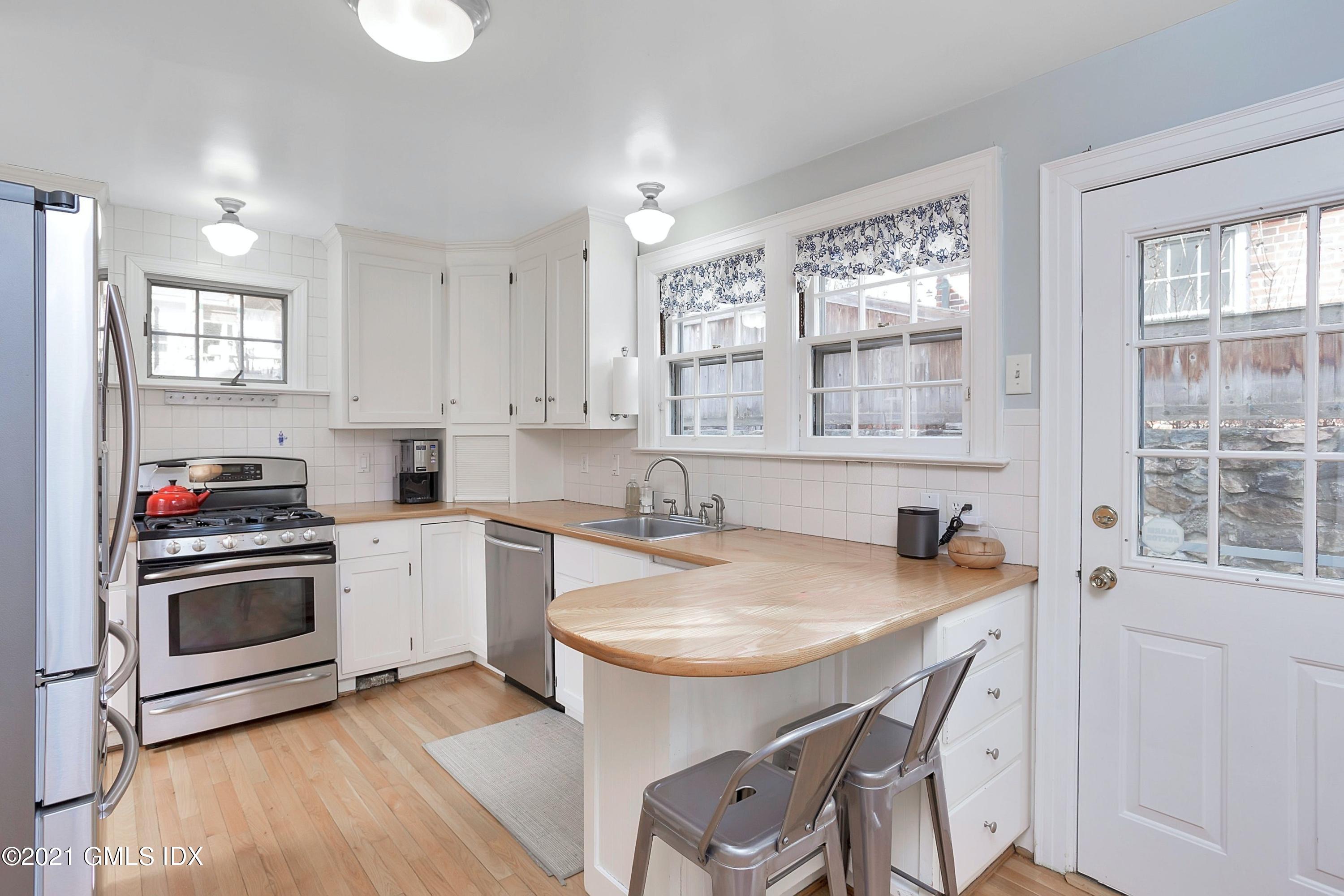 24 Valleywood Road Cos Cob, CT 06830 - Photo 4 of 24 a kitchen with sink a stove and chairs