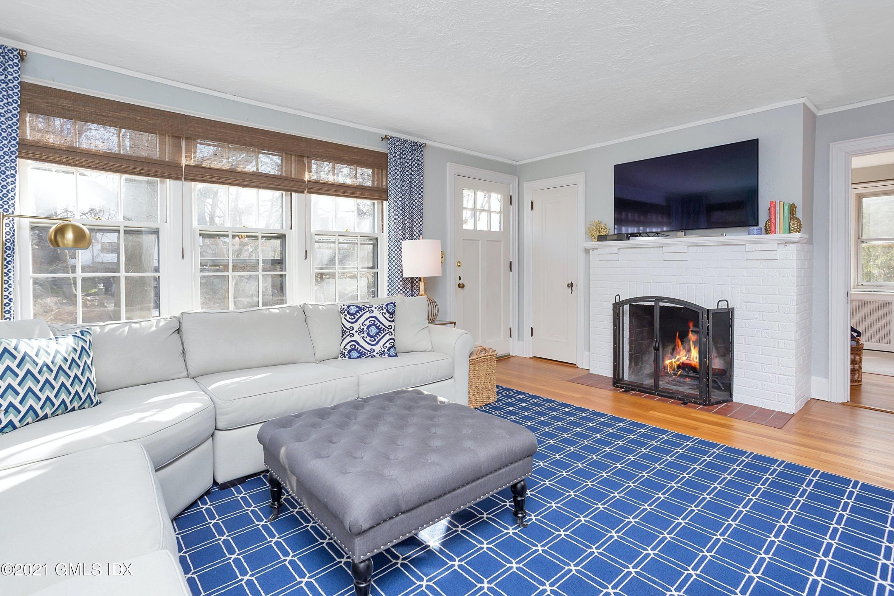24 Valleywood Road Cos Cob, CT 06830 - Photo 10 of 24 a living room with furniture a flat screen tv and a fireplace
