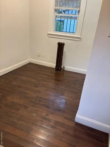 a view of a room with wooden floor and a window