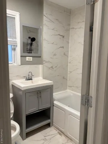 a bathroom with a bathtub a sink and a window