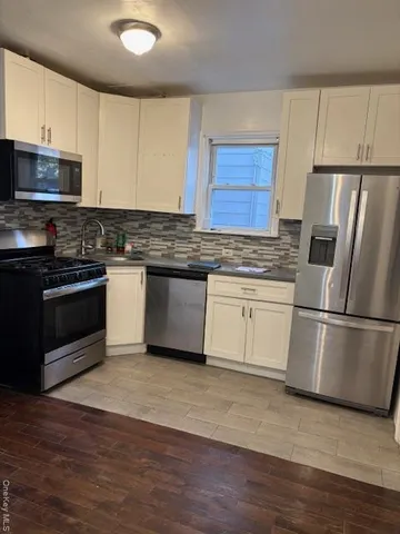 a kitchen with cabinets stainless steel appliances and a sink